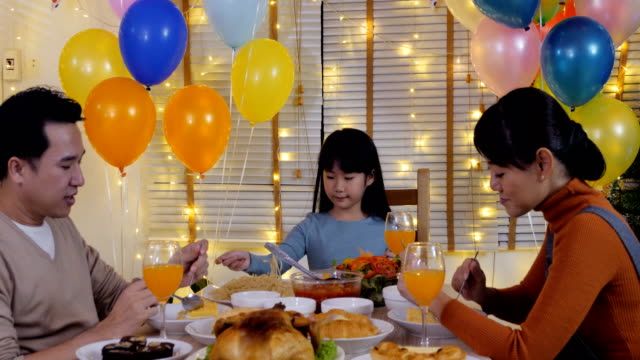 Little-girl-having-dinner-with-her-family-at-home.-Girl-enjoy-for-special-dinner-with-her-family.-People-with-party-and-celebration-concept.-4K-Resolution.