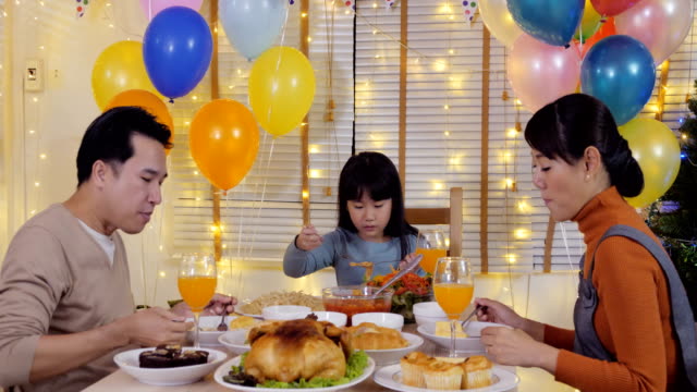 Little-girl-having-dinner-with-her-family-at-home.-Girl-enjoy-for-special-dinner-with-her-family.-People-with-party-and-celebration-concept.-4K-Resolution.