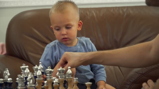 Padre-le-da-lecciones-de-ajedrez-a-su-pequeño-hijo