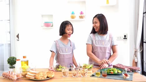 Mother-and-daughter-cooking-in-the-kitchen-at-home,-happy-family-asian-concept