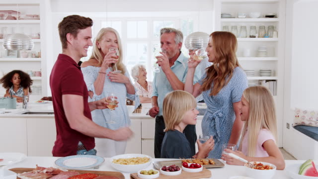 Group-of-family-and-friends-meeting-for-lunch-party-in-kitchen