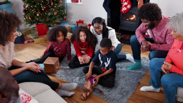 Eröffnung-der-Sohn-Geschenk-als-Multi-Generationen-Familie-Weihnachten-feiern-zu-Hause-zusammen