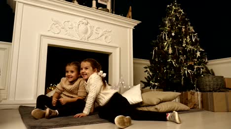 Two-little-girls-pose-during-Christmas-photo-session.-Studio-shooting-before-the-holidays