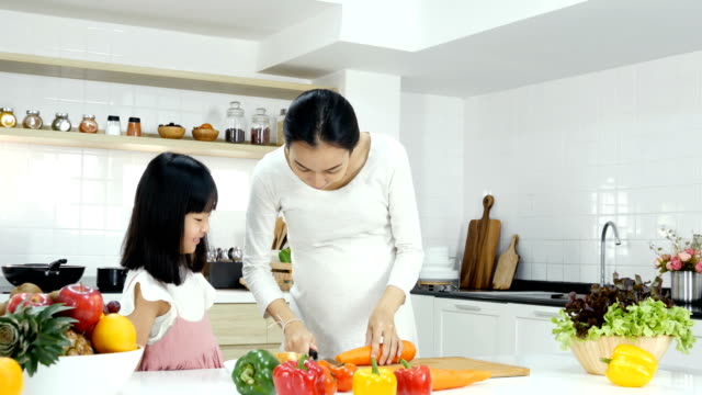 Kleines-Mädchen-versuchen,-alleine-in-der-Küche-kochen.-Mutter-lehrt-ihre-Tochter-zum-Kochen.-Menschen-mit-Lebensstil-und-gesunde-Konzept.