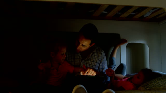 Vater-und-Kinder-mit-digital-Tablette-im-Schlafzimmer-zu-Hause-4k