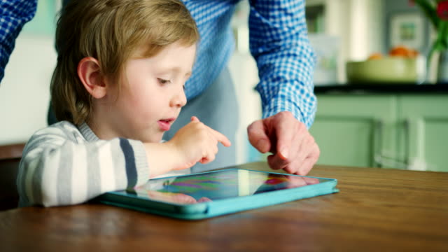 Hijo-de-padre-que-muestra-cómo-utilizar-la-tableta-Digital