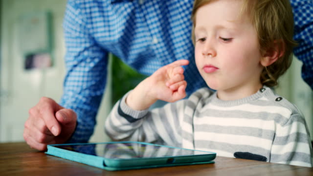 Hijo-de-padre-que-muestra-cómo-utilizar-la-tableta-Digital