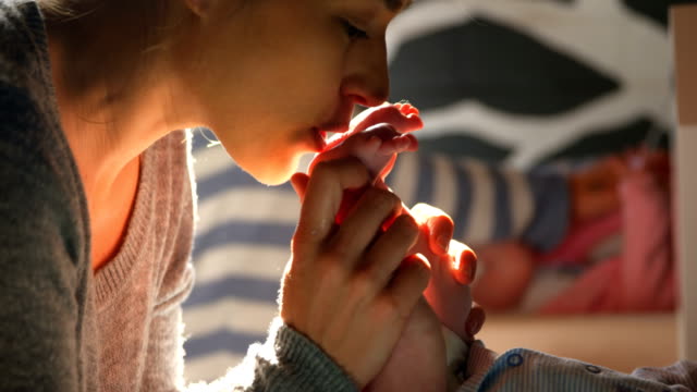 Mother-kissing-her-baby-feet-at-home-4k