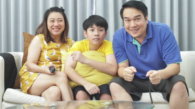 Slow-Motion-von-asiatischen-Familie-Vater-Mutter-und-Sohn-auf-Couch,-Looking-in-die-Kamera-Lächeln-begegnen.