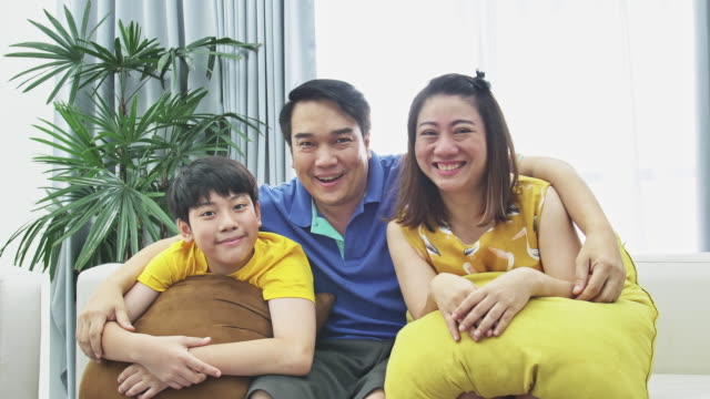 Slow-Motion-von-asiatischen-Familie-Vater-Mutter-und-Sohn-auf-Couch,-Looking-in-die-Kamera-Lächeln-begegnen.
