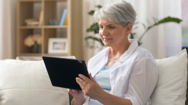 happy-senior-woman-with-tablet-pc-at-home