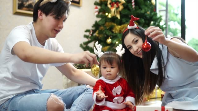 Glückliche-Familie-Mutter-Vater-und-Kind-Tochter-mit-Weihnachtsbaum-zu-Hause.-Closeup-Zeitlupe-Porträt-des-liebenden-Familie,-Frohe-Weihnachten-und-schöne-Feiertage!