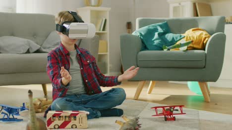 Niño-inteligente-usar-casco-de-realidad-Virtual-utiliza-gestos-para-controlar-el-juego-de-realidad-aumentada.-Él-está-sentado-sobre-una-alfombra-en-su-sala-de-estar.-Feliz-usa-AR-futuristas-gafas-en-casa.