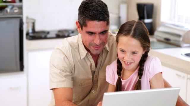 Vater-mit-dem-laptop-mit-seiner-Tochter
