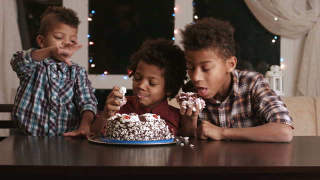 Tres-afro-muchachos-comiendo-pastel.
