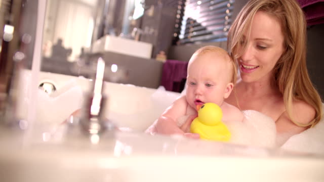 Moderno-Mamá-toma-baño-de-burbujas-con-bebé-hija