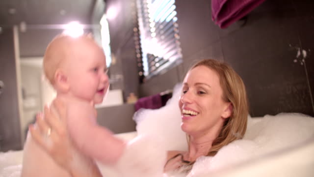 Moderno-Mamá-toma-baño-de-burbujas-con-bebé-hija