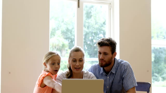 Una-familia-de-tres-está-usando-la-computadora-portátil
