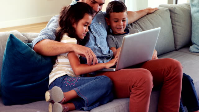 Glücklicher-Vater-mit-zwei-Kindern-mit-laptop
