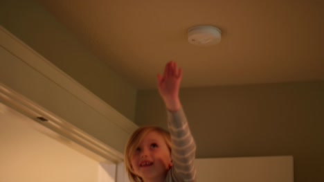 A-little-girl-sitting-on-her-mother's-shoulders-and-reaching-for-the-ceiling,-slow-motion