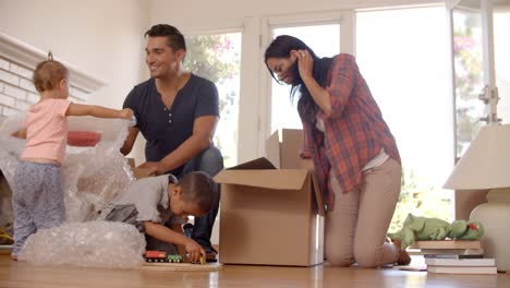 Family-Unpacking-Boxes-In-New-Home-On-Moving-Day