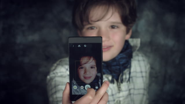 4K-Hi-Tech-Schuss-von-einem-Kind-macht-ein-Selbstporträt-auf-seinem-Smartphone