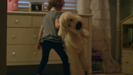 Sad-young-girl-walks-into-her-bedroom-holding-a-stuffed-animal-and-sits-on-the-floor