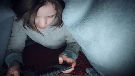 4k-Shot-of-Child-under-Blanket-Looking-on-Tablet