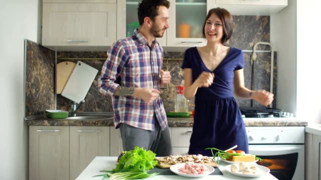 Glücklich-schönes-Paar-tanzen-und-küssen,-während-kochen-auf-der-Küche-zu-Hause