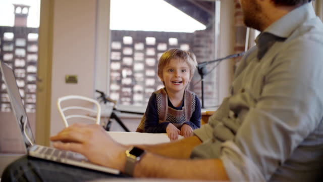 modern-family-little-girl--running-and-playing-at-home-with-dad-working-with-notebook.-indoor-in-modern-industrial-house.-caucasian.-4k-handheld-slow-motion-video-sho