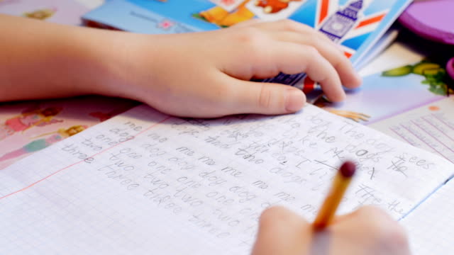 Hübsches-kleines-Mädchen-lernt,-am-Tisch-zu-schreiben