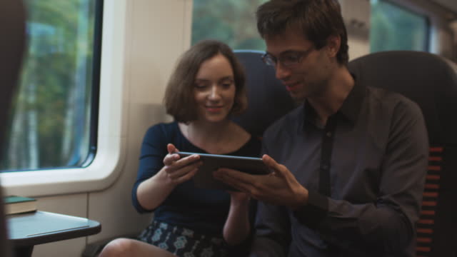 Mann-und-Frau-sind-Reisen-im-Zug-und-mit-Tablet-für-Unterhaltung