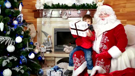 Santa-gibt-jungen-großen-vorhanden,-Wünsche-wahr,-glückliches-Kind-umarmt-Saint-Nicolas,-Geschenk-für-Kind-kommen