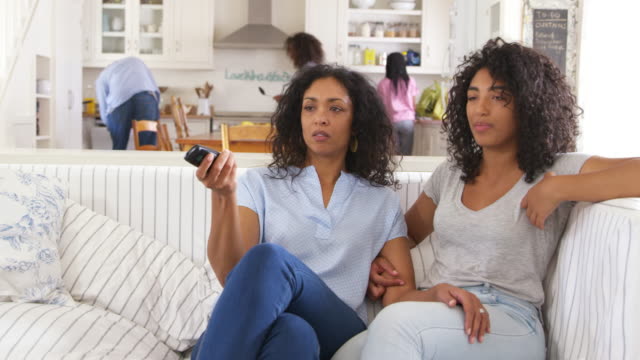 Madre-con-hija-adolescente-se-sienta-en-el-sofá-viendo-la-televisión-juntos