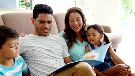 Happy-family-reading-book-in-living-room