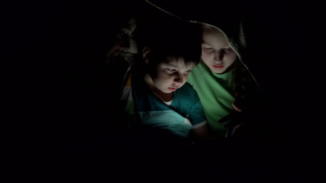 Kids-playing-in-the-tablet-under-the-covers