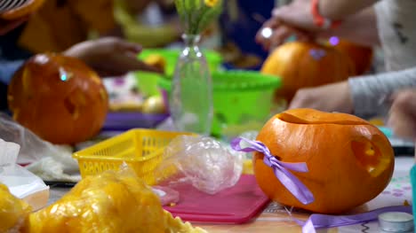 Konzept-der-familiären-Beziehungen.-Eltern-und-Kinder-Halloween-Feier-vorbereiten.-Schnitzen-Sie-und-dekorieren-Sie-Kürbisse-zusammen.-Kürbis-als-Herbst-Symbol-für-Halloween,-Thanksgiving,-Ernte-Parteien-und-Pumpkin-Spice-von-latte