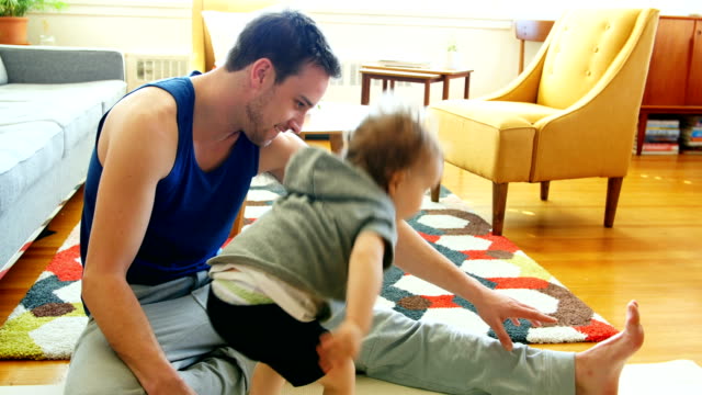Vater-mit-seinem-Baby-Boy-im-Wohnzimmer-4k-Ausübung