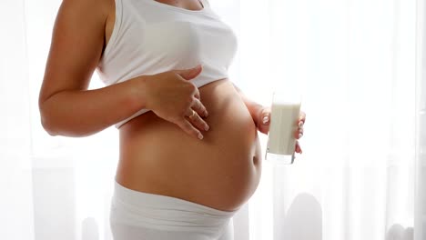 madre-con-gran-Panza-tiene-leche-de-vidrio-y-demuestra-pulgar-para-arriba-en-cámara-lenta,-una-nutrición-saludable