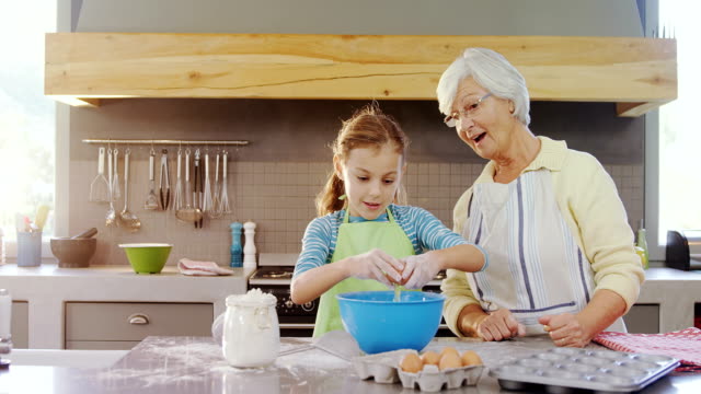 Little-girl-break-egg-in-bowl-and-grandma-happily-applauding-4K-4k