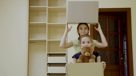 Dos-niñas-felices-con-cajas-reubica-en-una-casa-nueva