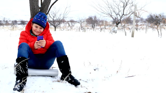 Kind-mit-Smartphone-in-Winter-park