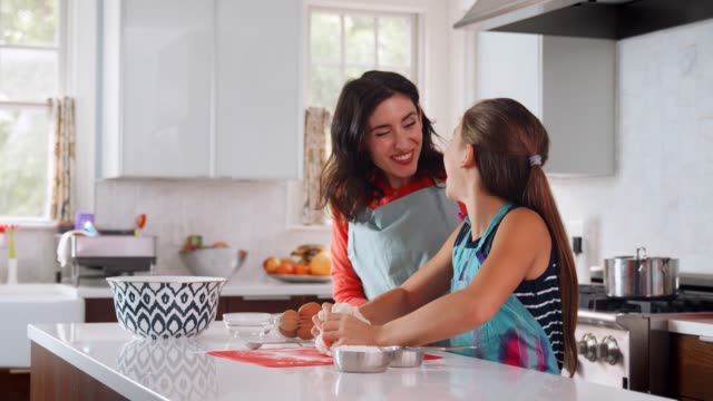Jewish-daughter-enjoys-kneading-challah-dough-with-mother