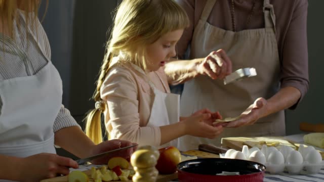 Little-Girl-Preparing-Cookies-with-Mother-and-Grandmother