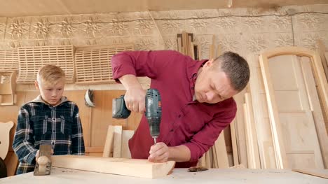 family,-carpentry,-woodwork-and-people-concept.-father-teaches-son-carpentry.