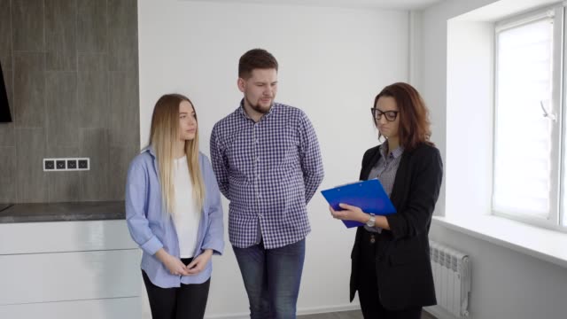 Family-of-two-and-real-estate-agent-discussing-contract-indoor