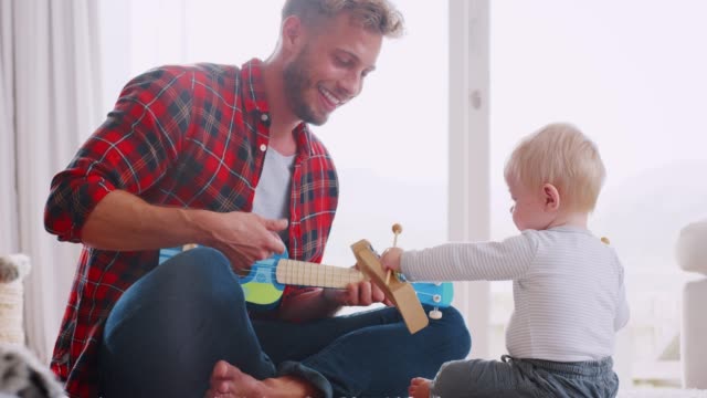 Dad-and-toddler-son-playing-with-instruments,-close-up