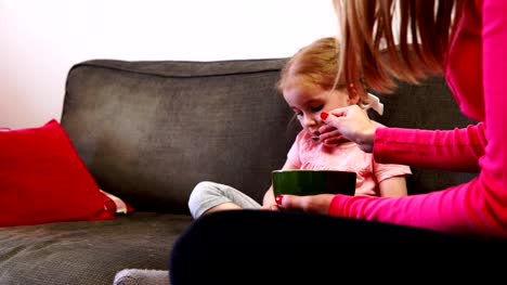 Mom-feeds-a-little-girl-who-can't-take-her-eyes-off-her-smartphone