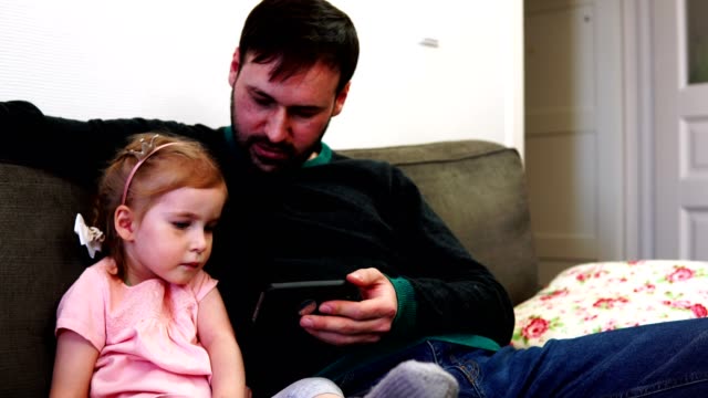 Tochter-und-Vater-in-das-Smartphone-schauen-und-diskutieren,-was-sie-sahen