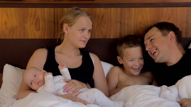 Family-of-four-together-in-bed-at-home